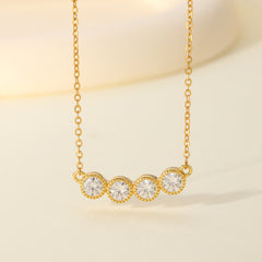 Gold necklace with three clear gemstones on a beige background