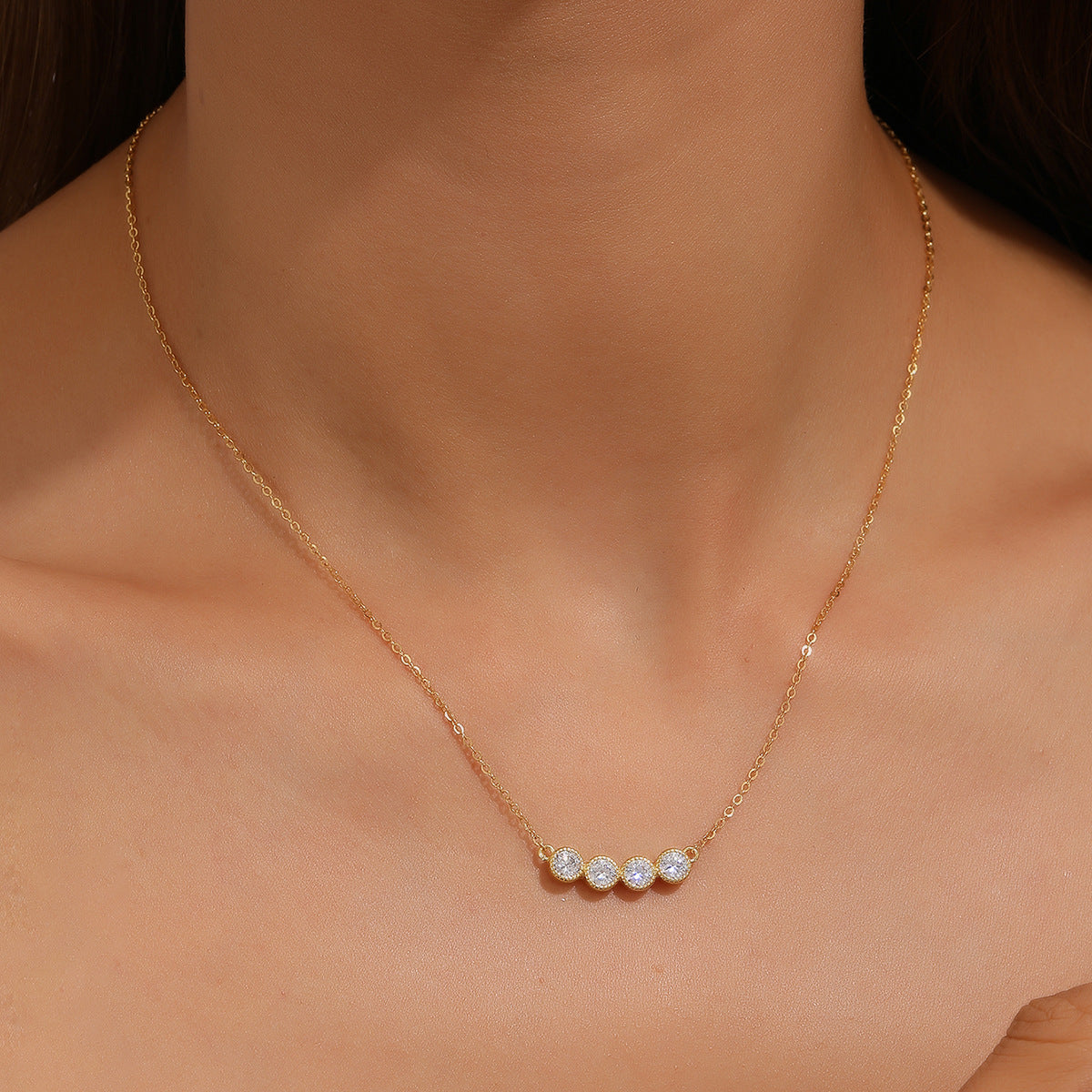 Gold necklace with three small diamonds on a person's neck