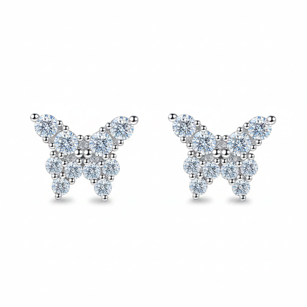 Butterfly-shaped earrings on a teal glittery background
