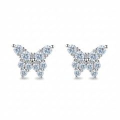 Butterfly-shaped earrings on a teal glittery background