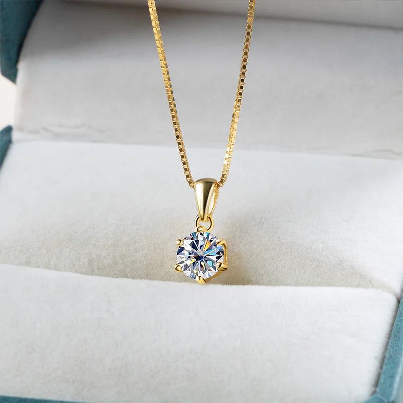 Gold moissanite pendant necklace presented on cushion