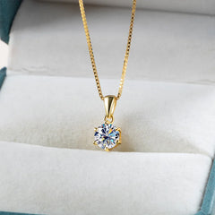 Gold moissanite pendant necklace presented on cushion