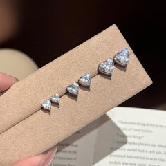 Heart-shaped diamond earrings on a brown card