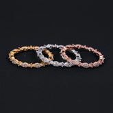Three diamond bracelets in gold, silver, and rose gold on a black background