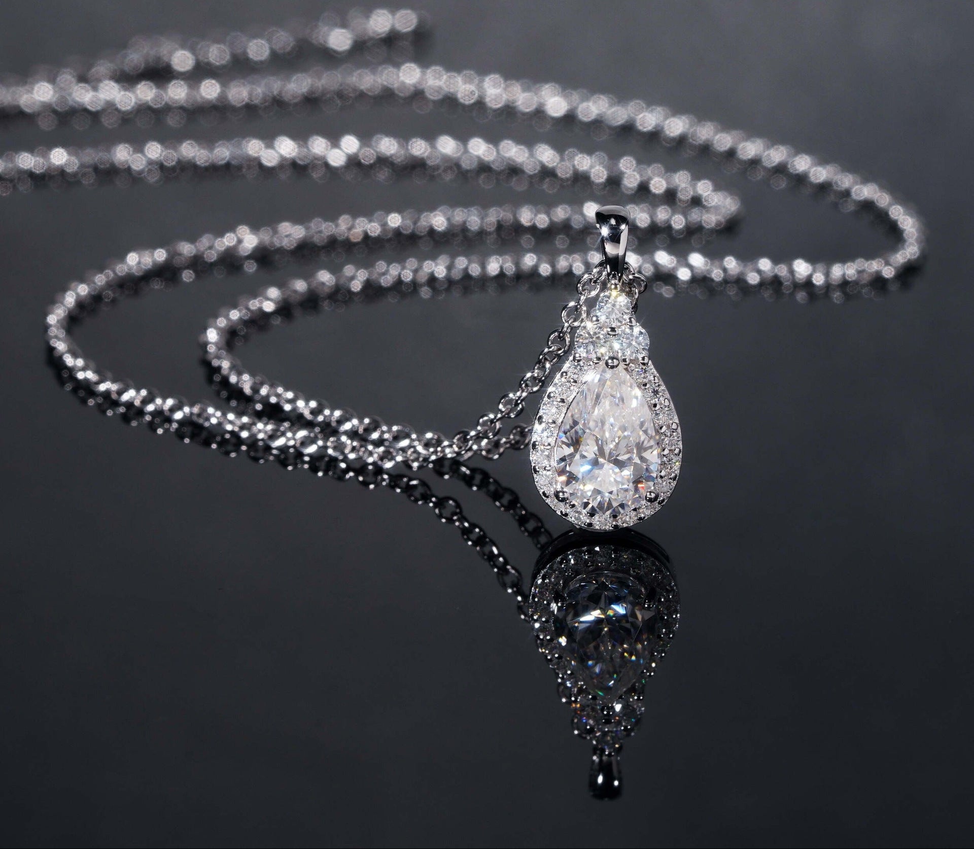 Silver necklace with a teardrop-shaped pendant on a dark background, featuring the brand 'Zuanfa'.