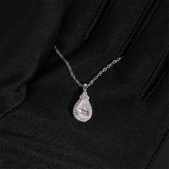 Silver teardrop pendant necklace on a black fabric background