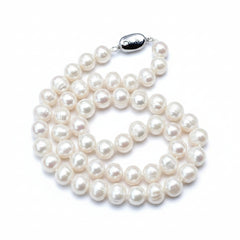 Pearl necklace on light gray fabric background