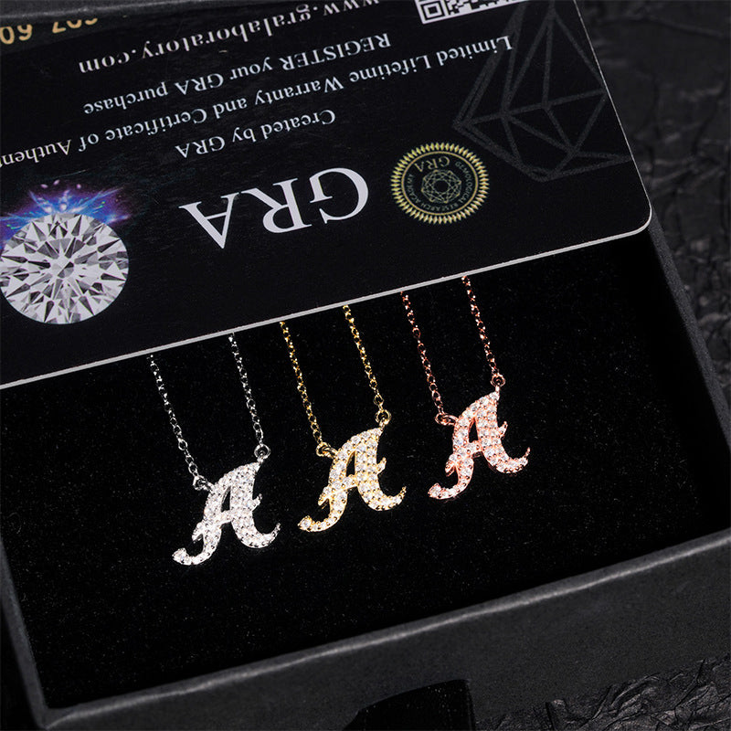 Three letter 'A' necklaces on a black card with 'GRA' branding.