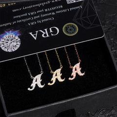Three letter 'A' necklaces on a black card with 'GRA' branding.