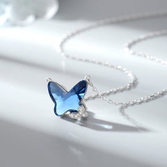 Blue butterfly-shaped pendant on a silver chain against a light background