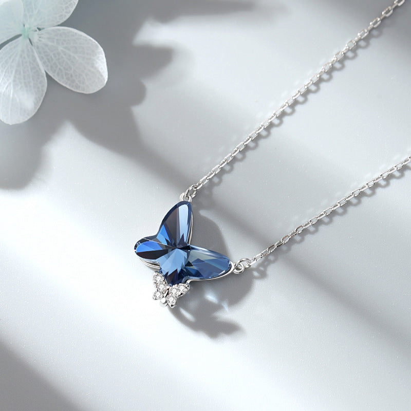 Butterfly-shaped blue gemstone necklace on a light background
