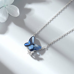 Butterfly-shaped blue gemstone necklace on a light background
