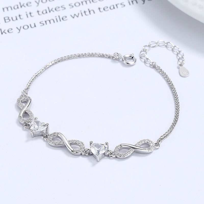 Silver bracelet with heart-shaped charms on a white background Silver bracelet with infinity symbols Aru Collection