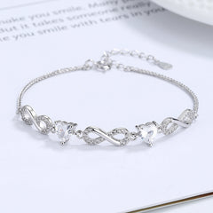Silver bracelet with heart-shaped crystals on a white surface Silver bracelet with infinity symbols Aru Collection