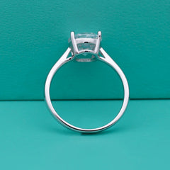 Silver ring with a diamond on a teal background