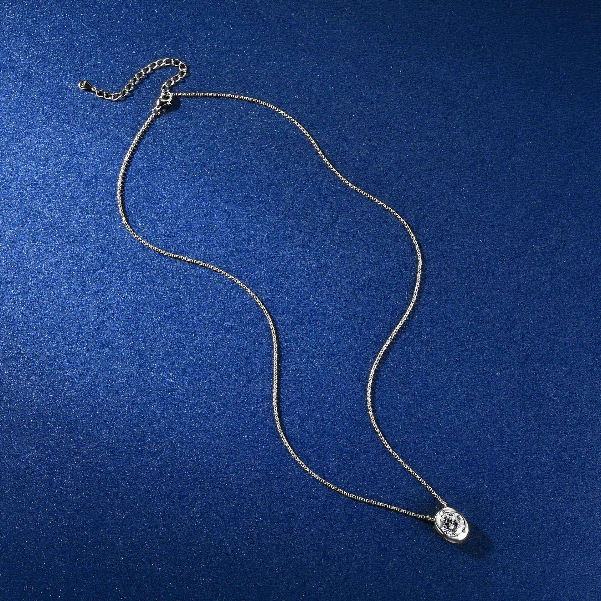 Silver necklace with a pendant on a blue background