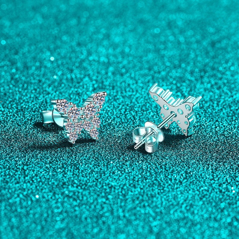 Butterfly-shaped silver earrings on a turquoise glittery background Butterfly Earrings for Women S925 Sterling Silver Moissanite  Aru collection