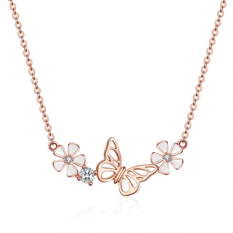Rose gold butterfly necklace with flowers on a white background