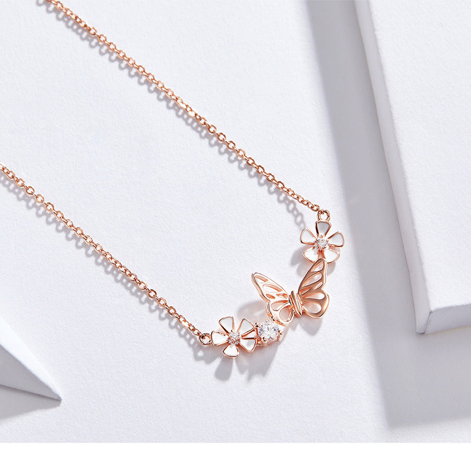 Rose gold butterfly necklace on a white background