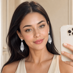 Woman wearing silver feather stud earrings, mirror selfie