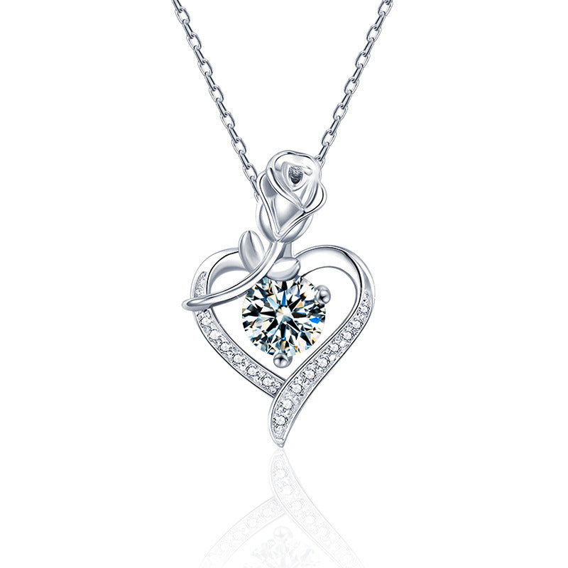 Silver heart-shaped necklace with a central gemstone on a white background