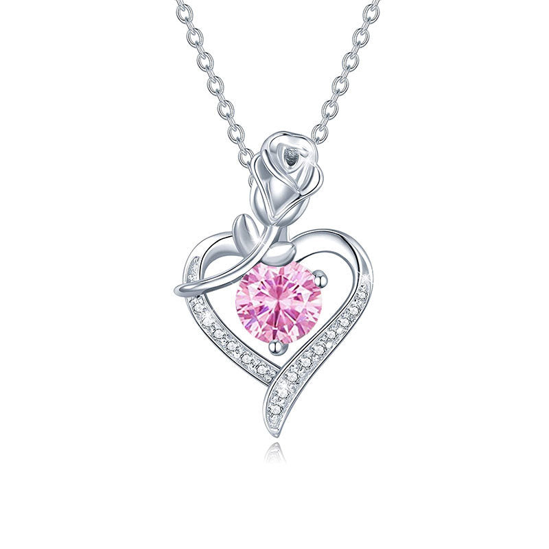 Silver necklace with a pink gemstone heart pendant on a white background