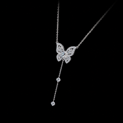 Butterfly-shaped necklace with dangling elements on a black background