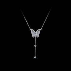 Butterfly necklace with dangling crystals on a black background, branded 'SHINY'.