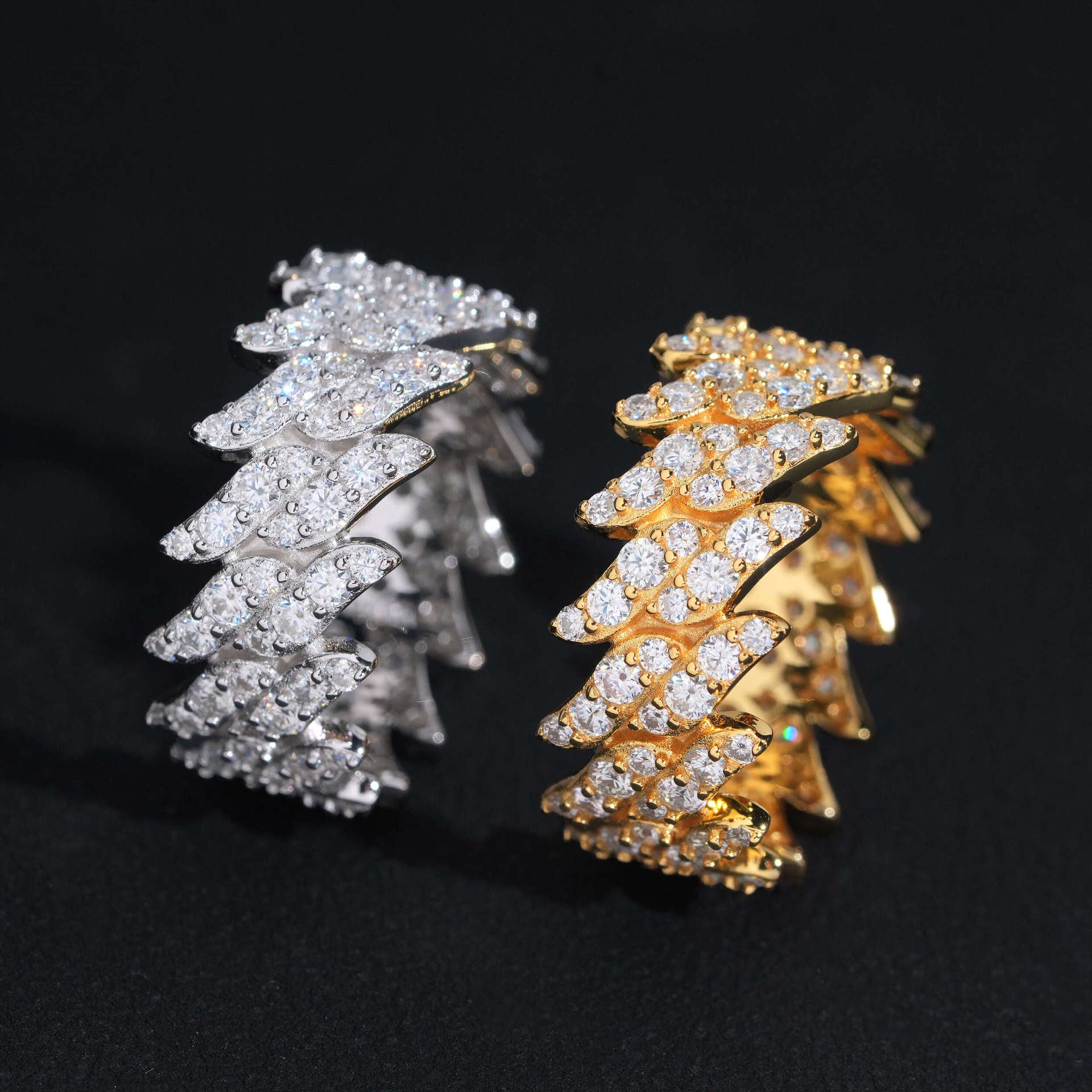 Gold and silver tree-shaped jewelry pieces on a black background