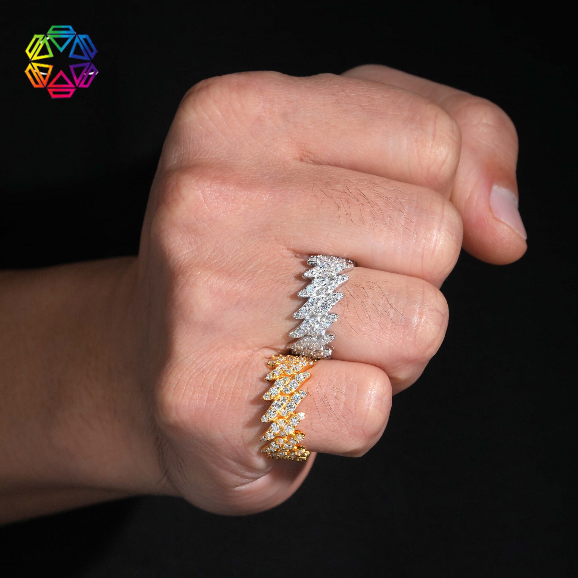 Hand wearing two diamond rings on a black background