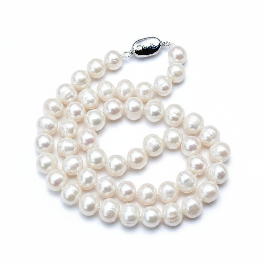 Pearl necklace on light gray fabric background