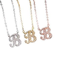 Three letter 'B' necklaces in different colors on a black background