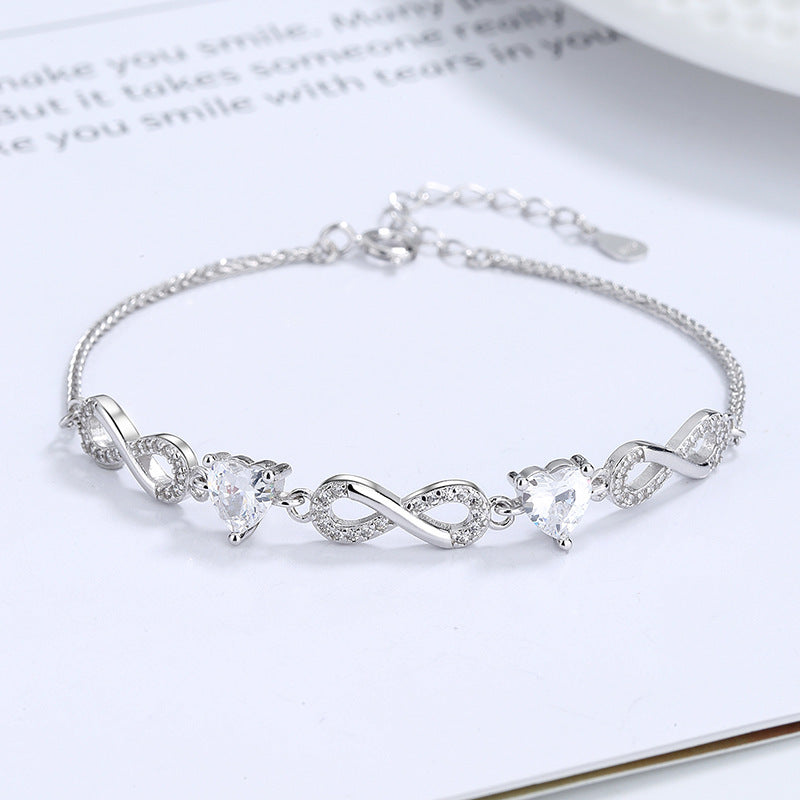 Silver bracelet with heart-shaped crystals on a white surface Silver bracelet with infinity symbols  Aru Collection 